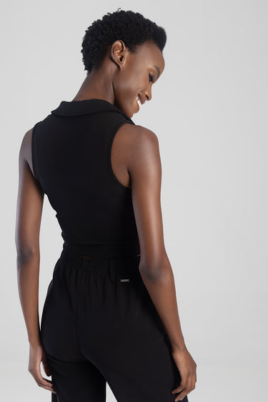 back view of a model in a black sleeveless knit waistcoat with a small collar and matching pants