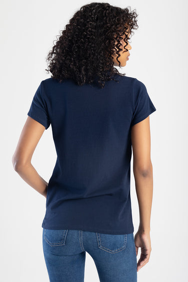back view of a navy blue short sleeve top paired with blue jeans