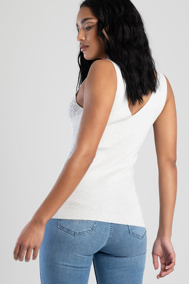woman in a white sleeveless tank top with beaded embellishments, back view, paired with blue denim jeans.
