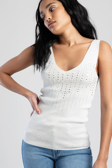 woman wearing white knit tank top with rhinestone details and blue jeans by Blue Jean Traders