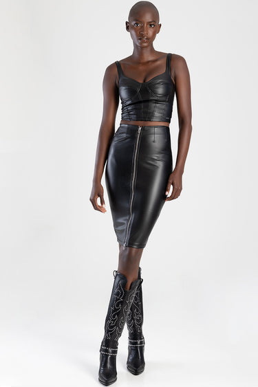 model wearing black leather corset top and matching front zip pencil skirt, paired with black studded cowboy boots