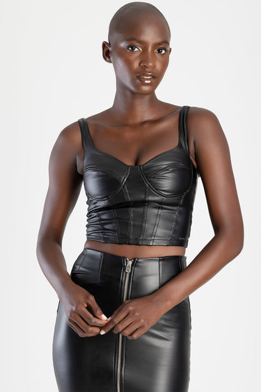 model wearing a black leather cropped corset top with structured cups and wide straps, paired with a high waisted black