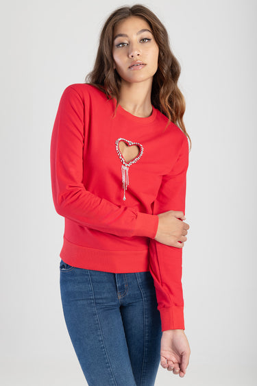 woman wearing red long sleeve top with heart rhinestone embellishment