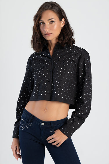 black cropped shirt with white polka dots, button front, long sleeves, collared with chest pocket, worn with dark wash jeans