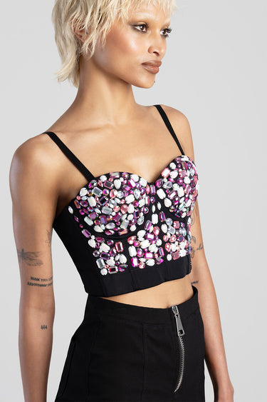 woman in a black beaded cropped corset top with pink and clear crystal embellishments and thin straps