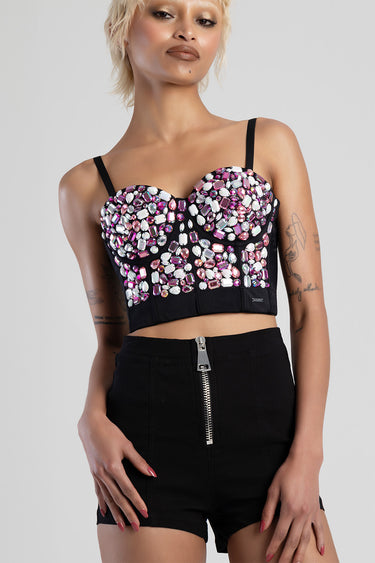 woman in a black cropped corset top encrusted with pink and clear gems and thin straps