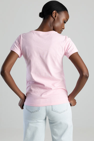 back view of a person wearing a light pink short sleeve top and light blue jeans