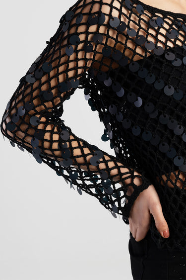 black knit top with a netted mesh and round sequins along the long sleeve
