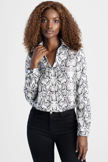 woman wearing snake print long sleeve blouse with collar tucked into black jeans