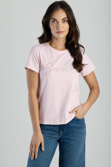 woman wearing light pink short sleeve t shirt with multicoloured dotted script graphic, paired with blue jeans, hand in