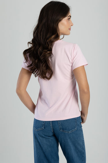 woman in a light pink short sleeve t shirt and blue jeans, back view