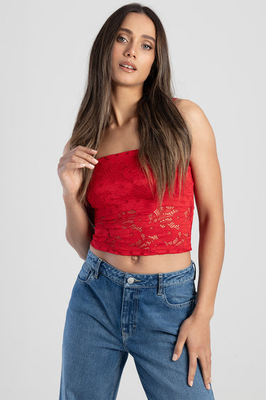woman wearing red lace crop top with thin straps and blue denim jeans