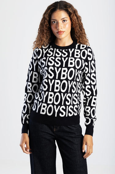woman wearing a black and white knit sweater with an allover bold letter pattern and ribbed crew neck and cuffs