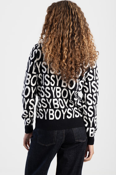 person wearing a black and white knit sweater with large repeating letters, back view, curly hair, ribbed cuffs and hem