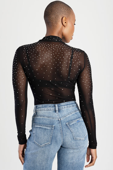 back view of a sheer black long sleeve top dotted with small white pearls paired with light wash jeans