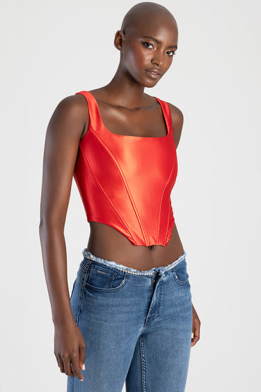 red satin corset top with wide straps shown on a model paired with blue denim jeans