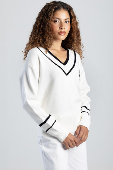 woman wearing Blue Jean Traders white knit v neck sweater with black trim and striped cuffs