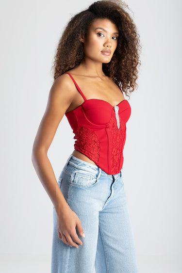 Blue Jean Traders red lace corset top with thin straps and light wash jeans model posing