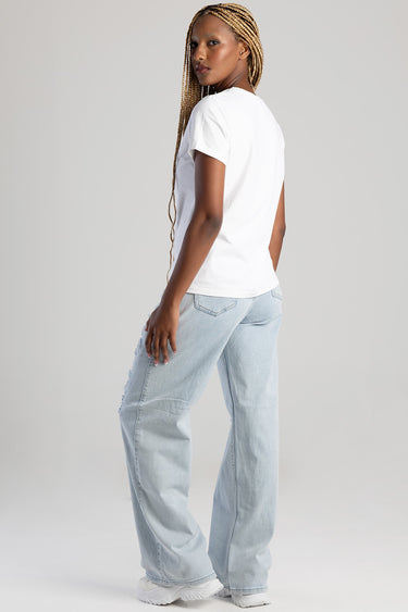 woman in white short sleeve t shirt and light wash wide leg jeans, back view