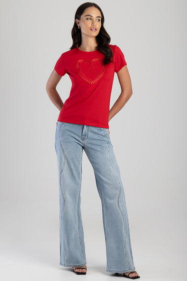 woman in red short sleeve t shirt with heart design and light blue wide leg jeans