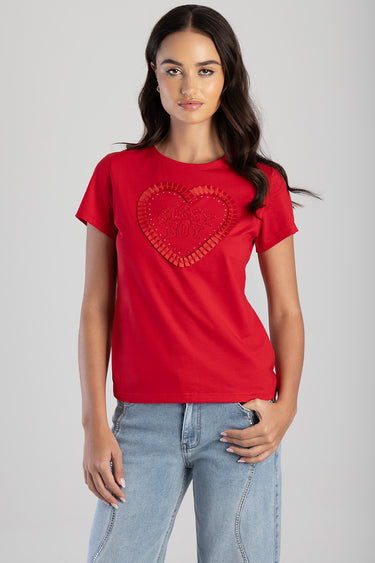 red short sleeve t shirt with a heart applique and ruffled border, worn with light wash jeans by a female model