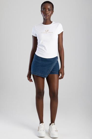 woman wearing white short sleeve t shirt with gold logo, blue wrap denim mini skirt, white sneakers
