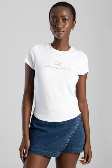 woman wearing white short sleeve crew neck t shirt with gold script logo on chest and a blue denim wrap skirt