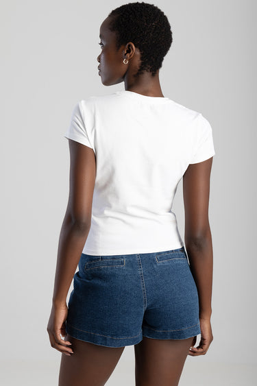 back view of a person wearing a white short sleeve t shirt and blue denim shorts