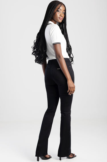 blue jean traders white knit top with short sleeves and black trim, paired with black flared pants; model with long braided