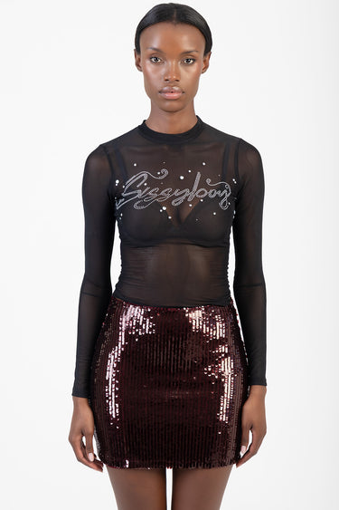 woman model wearing a sheer black long sleeve top with rhinestone script and a burgundy sequined mini skirt