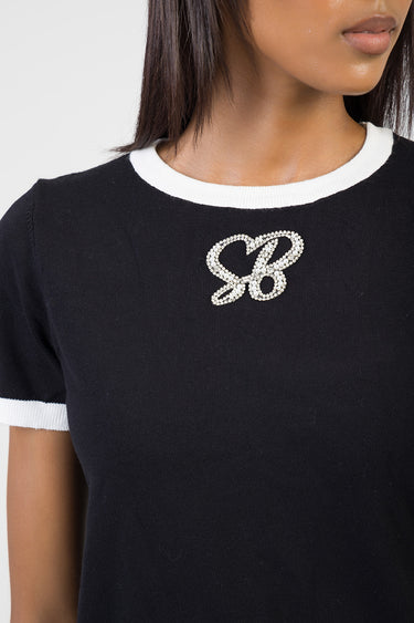 black knit top with white crew neck and cuffs featuring a crystal rhinestone bow applique on the chest