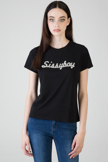 woman wearing a black short sleeve t shirt with a silver rhinestone logo across the chest and blue jeans