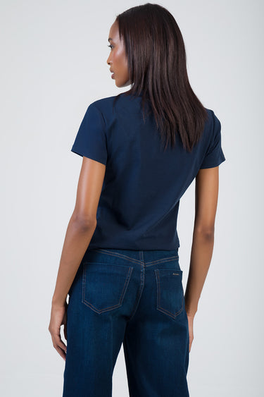 woman in navy short sleeve t shirt paired with dark wash jeans seen from behind
