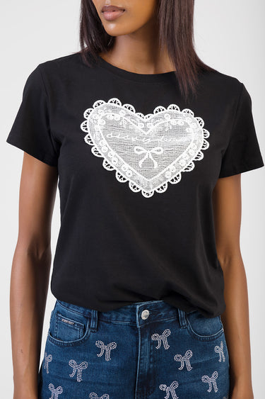 black short sleeve t shirt with a white lace heart design on the chest, worn with blue jeans that have white rhinestone