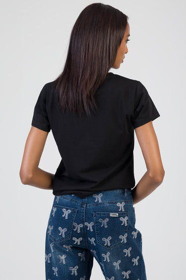 back view of a person wearing a black short sleeve t shirt and blue jeans with white bow patterns