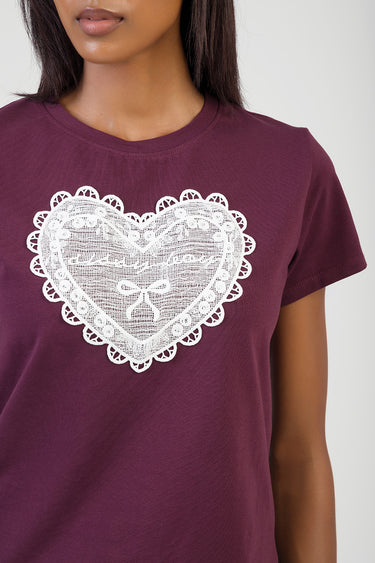 woman wearing burgundy short sleeve t shirt with large white lace heart graphic on front