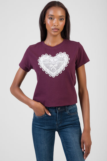 woman in a burgundy short sleeve t shirt with a white lace heart graphic on the chest