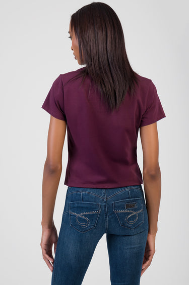 woman wearing a burgundy short sleeve top and blue denim jeans, back view