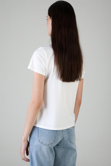 back view of a woman wearing a white short sleeve t shirt and light blue jeans