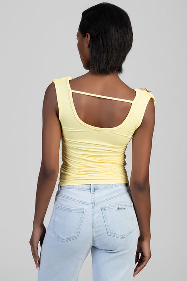 woman from the back wearing a pale yellow ruched sleeveless top with a thin back strap and light wash jeans