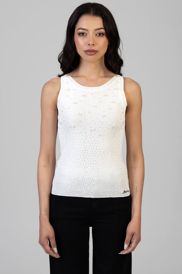 woman wearing a white sleeveless knit top with pearl embellishments and a dotted gradient pattern, paired with black trousers