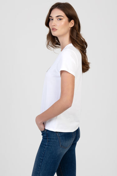 woman in a white short sleeve t-shirt with blue jeans, side profile