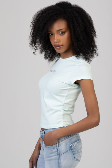 side view of a woman in a light mint short sleeve top with a small chest logo by blue jean traders