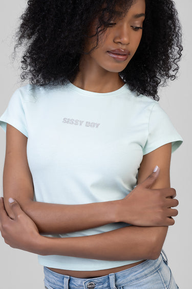 woman with curly hair wearing pastel blue cropped short sleeve t shirt with glitter print