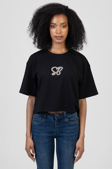 woman wearing black boxy short sleeve t shirt with rhinestone butterfly motif on chest