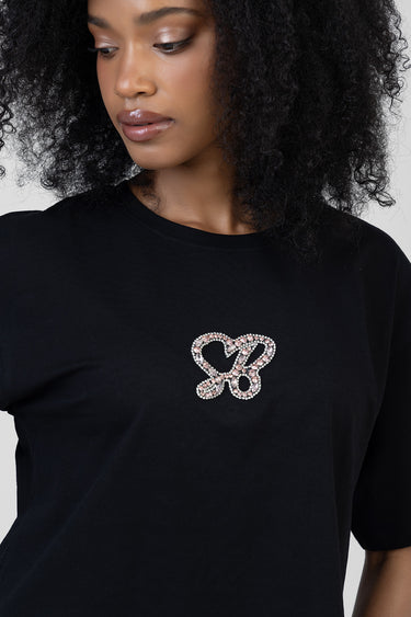 woman wearing a black t shirt with a pink and clear rhinestone butterfly design on the chest