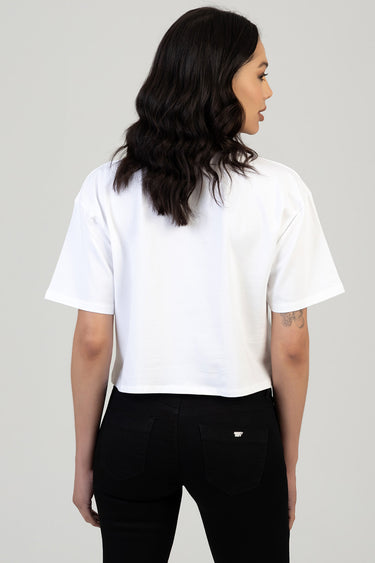 back view of woman wearing a white boxy short sleeve t shirt and black jeans