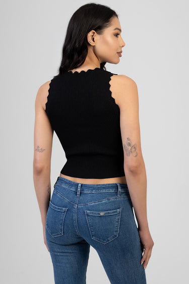 woman wearing a black ribbed sleeveless knit top with scalloped edges, back view