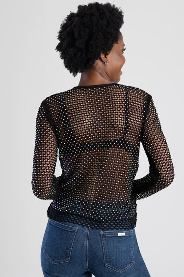woman in black mesh top with rhinestone detailing seen from behind, blue jeans