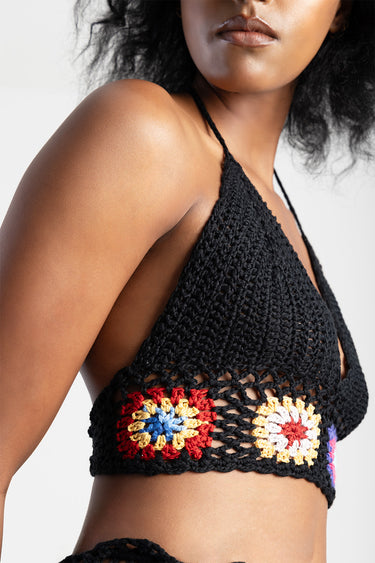 black crochet halter top with colourful granny square band along the hem, close up of shoulder and neckline